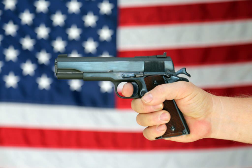 Gun held in front of American flag