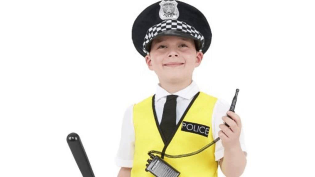 Young boy, smiling proudly,  wearing police uniform holding a whistle and a truncheon