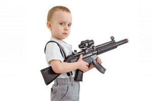Boy with toy machine gun isolated on a white background