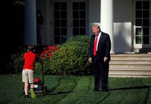 Child struggling with his job watches a kid with a lawnmower